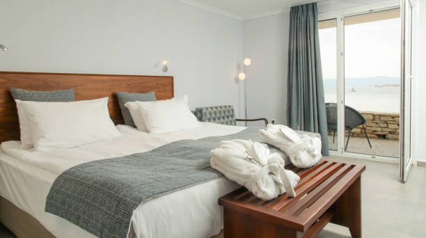 istock Simple and cozy bedroom with king size bed in neutral tones. 1345951995