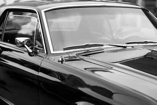 Windshield of black vintage classic American car, black and white image