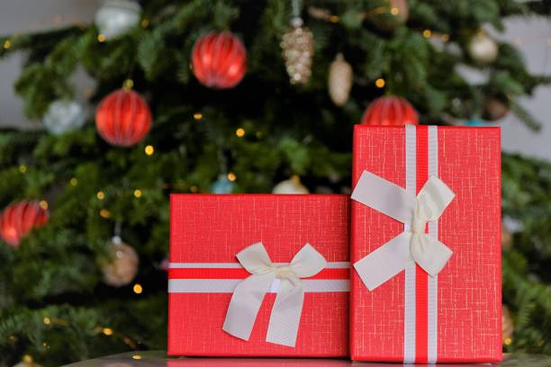 istock Christmas presents. Red gift boxes on Christmas tree background 1345953495