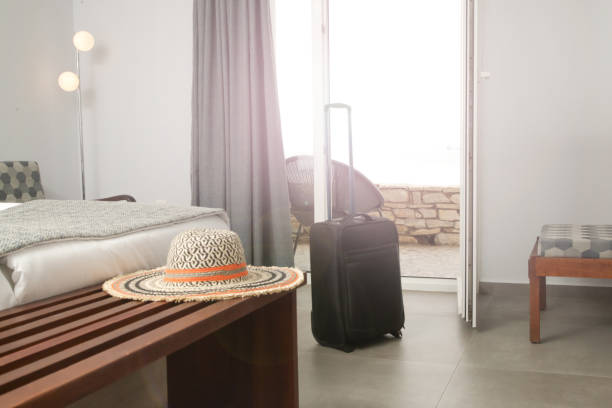 istock Luggage and straw hat in hotel room 1345953701