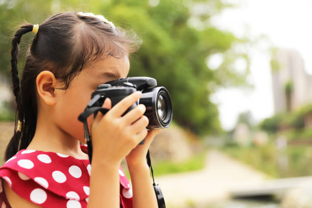 istock a Asian girl take photos with a digital camera. 1345954674
