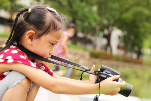 istock a Asian girl take photos with a digital camera. 1345954784