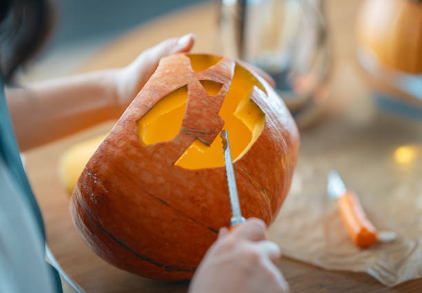 istock woman is carving pumpkin 1345954796