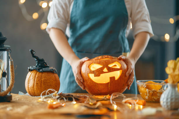 istock woman is carving pumpkin 1345954832