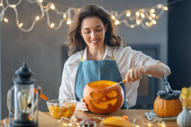 istock woman is carving pumpkin 1345954895