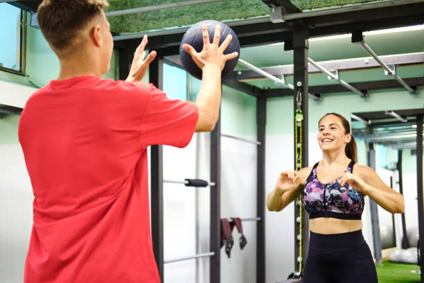 istock Two people at the gym doing a medicine ball exercise. 1345957988