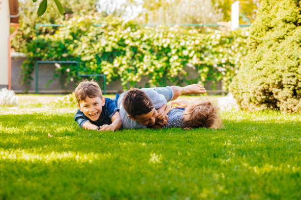 istock Full Length Of Happy Boy Lying On Grass 1345959331