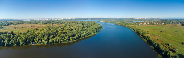 istock Section of wide plain river with distant city, aerial view 1345961098