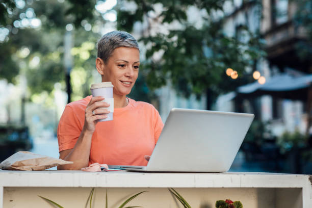 istock Woman using laptop at the outdoor cafe 1345961688