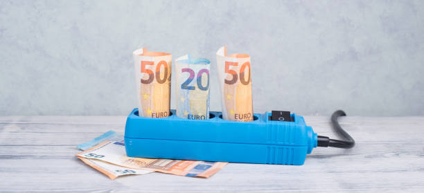 Euro banknotes in a power outlet, rising prices, expensive green electricity stock photo