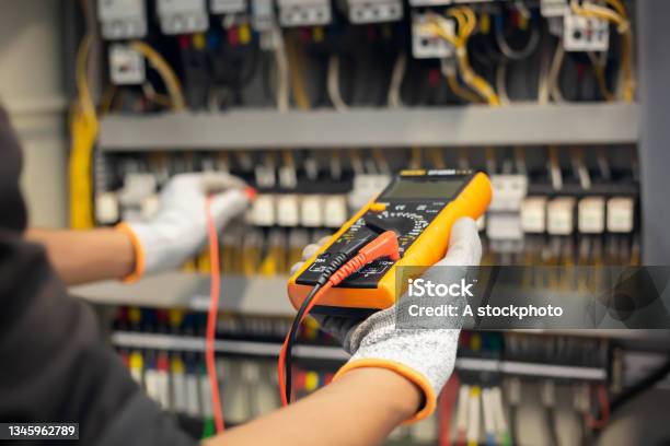 Electrician Engineer Uses A Multimeter To Test The Electrical Installation And Power Line Current In An Electrical System Control Cabinet Stock Photo - Download Image Now