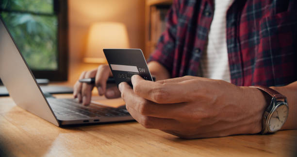 istock Young man making payment and shopping by credit card 1345963686