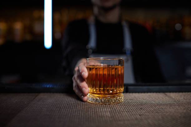 istock Barman holding out glass with alcoholic cocktail 1345966747