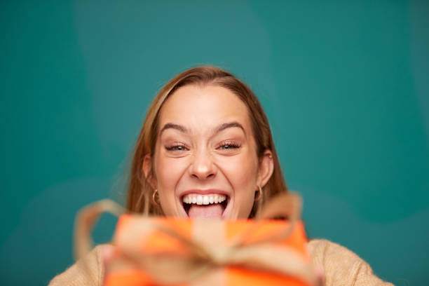 istock A young beautiful woman making a face and holding a Christmas gift. 1345967020