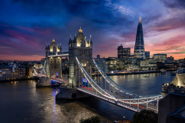Elevated dusk view to the illuminated Tower Bridge and skyline of London Elevated view to the illuminated Tower Bridge and urban skyline of London along the river Thames, UK, just after sunset color intensity stock pictures, royalty-free photos & images