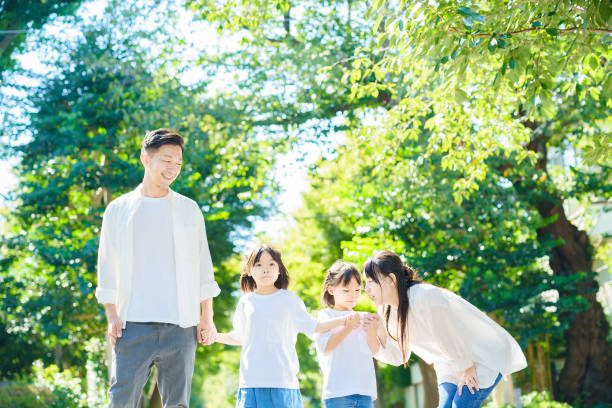 散歩する4人の家族 - family walking parent lifestyles ストックフォトと画像