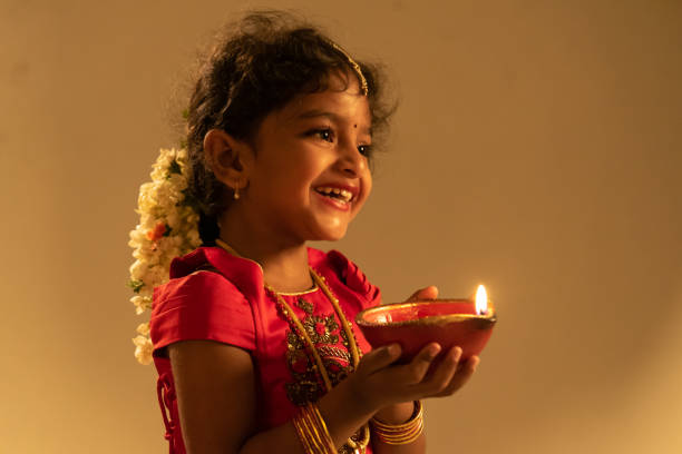 young Indian girl holding Diwali oil lamp stock photo