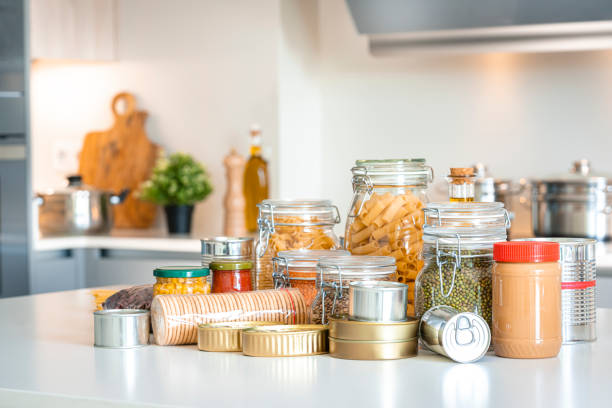 Glass jars with bulk products on kitchen counter. Organization of storage in the kitchen. Oatmeal, cornflakes, spaghetty are stored in glass containers.
