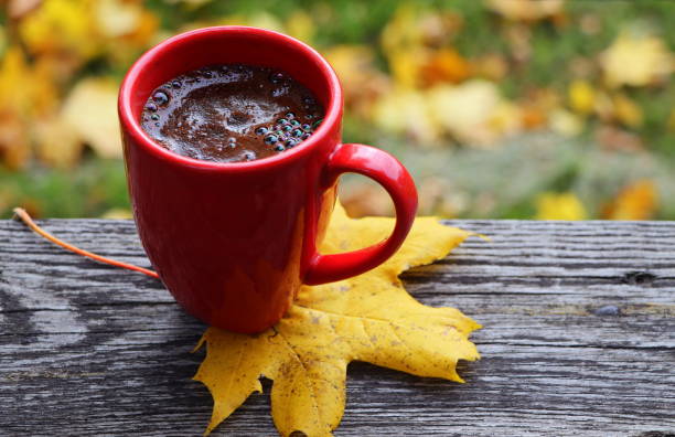 istock Fall background. Blurred autumn leaves background with hot cup of coffee 1345972908