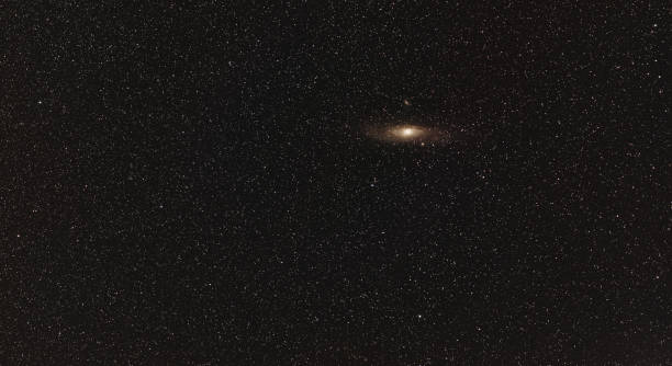 Night sky, many stars, Andromeda galaxy visible. Long exposure stacked photo