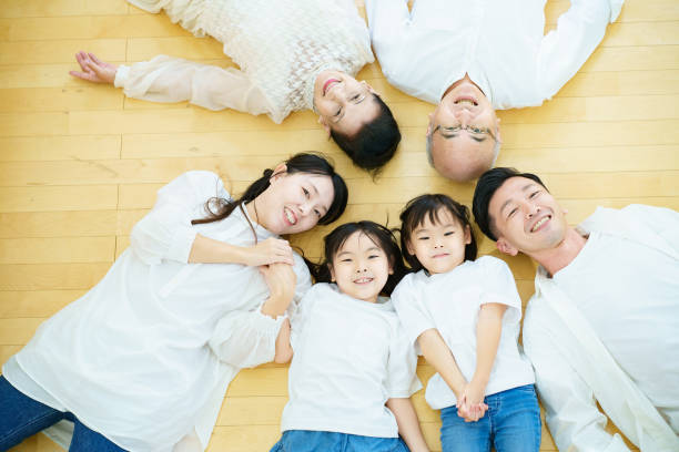 istock 3 generation family lying on the floor 1345974797
