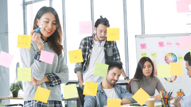 istock Diversity multi-ethnic group brainstorming teams with business partner meeting and share ideas in conference room. Creative design colleague talking strategy plan use sticky notes post, present ideas 1345976705