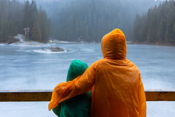 istock Two kids on raincoats enjoying lake 1345979112