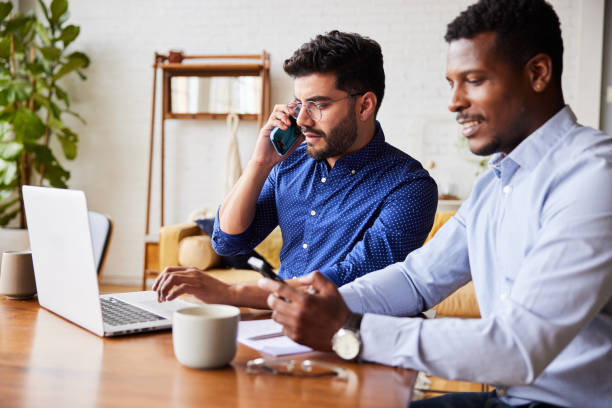 istock Diverse young businessmen using their phones in a home office 1345979195
