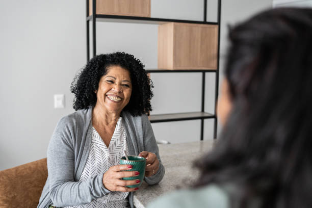 istock Happy friends talking and drinking coffee at home 1345979348