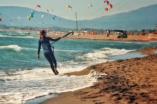 Kitesurfer girl walking down the sea coast