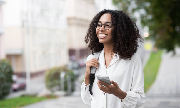 istock Happy woman using smart phone in a city 1345981320
