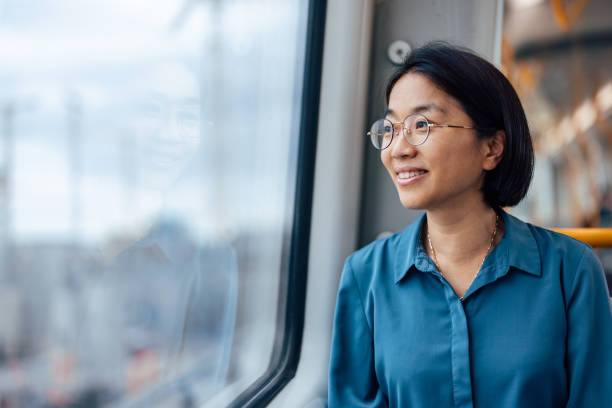 Smiling woman looking through window while traveling by bus.