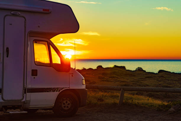 istock Camper vehicle on beach at sunrise 1345983036