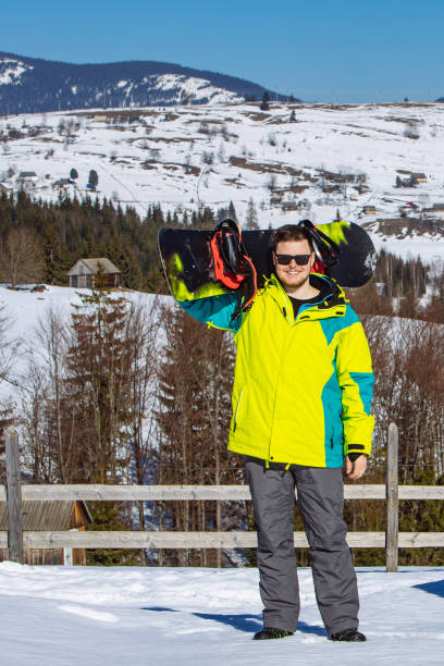 istock man in sunglasses holding snowboard 1345984443