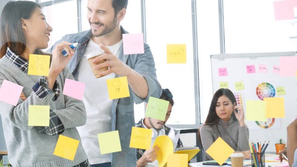 istock Diversity multi-ethnic group brainstorming teams with business partner meeting and share ideas in conference room. Creative design colleague talking strategy plan use sticky notes post, present ideas 1345985073