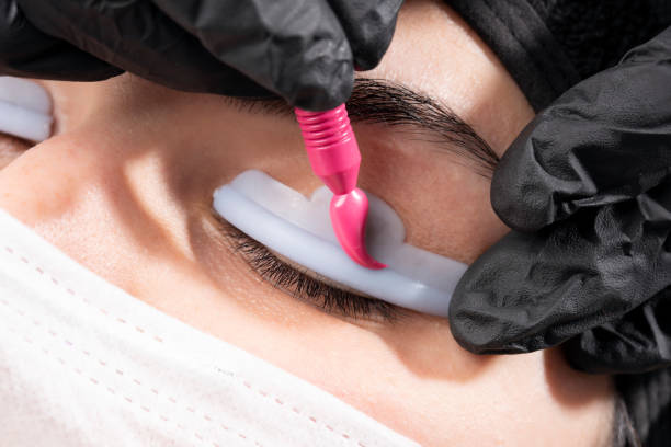 Beautician is applying permanent make up Beautician is applying eyelash straightening. Beautiful young woman in beauty salon on eyebrow makeup treatment. Beautician doing eyebrows tattooing. permanent makeup before and after stock pictures, royalty-free photos & images