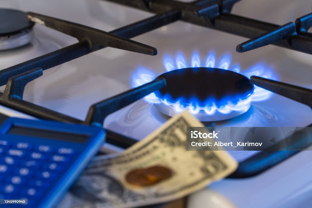 gas burner, shortage Shortage and gas crisis. Money and a calculator on the background of a burning  gas stove Natural Gas Stock Photo