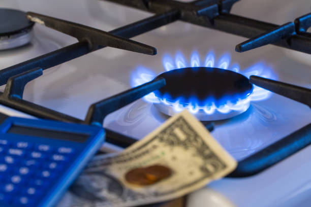 gas burner, shortage Shortage and gas crisis. Money and a calculator on the background of a burning gas stove money shortage stock pictures, royalty-free photos & images