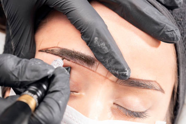 Beautician is applying permanent make up Beautician is using a machine. Beautiful young woman in beauty salon on eyebrow makeup treatment. Beautician doing eyebrows tattooing. permanent makeup before and after stock pictures, royalty-free photos & images