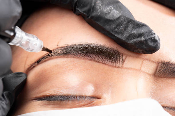 Beautician is applying permanent make up Beautician is using a machine. Beautiful young woman in beauty salon on eyebrow makeup treatment. Beautician doing eyebrows tattooing. permanent makeup before and after stock pictures, royalty-free photos & images