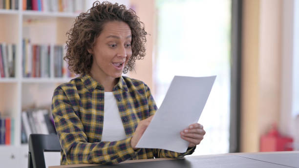 istock Excited Indian Woman Celebrating Success on Documents, 1345991106