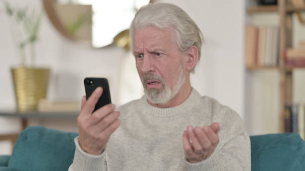istock Senior Old Man Loss on Smartphone 1345991541
