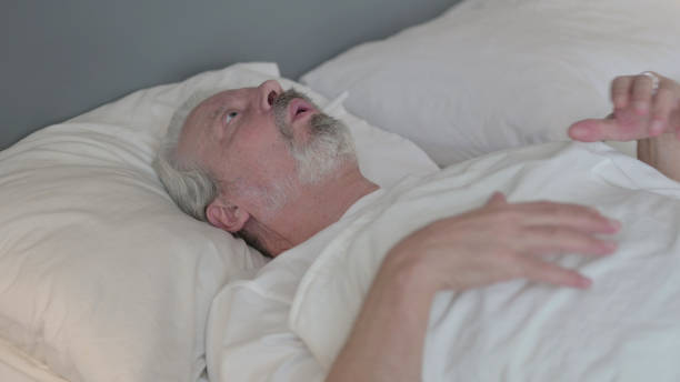 istock Senior Old Man Waking up from Nightmare in Bed 1345991699