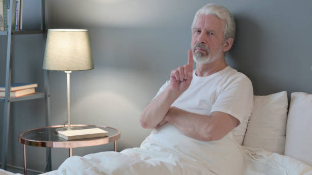 istock No Sign by Senior Old Man Sitting in Bed, Disapprove 1345993987