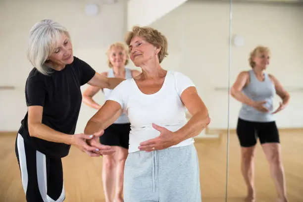Photo of Female dance instructor teaching elderly woman ballet technique