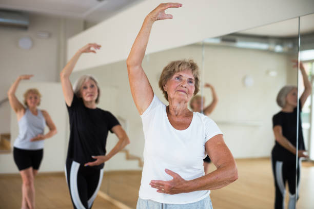 istock Elderly woman practicing ballet dance moves in choreographic studio 1345995593
