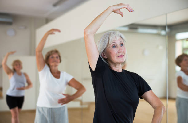 istock Aged woman practicing ballet dance moves in choreographic studio 1345995594
