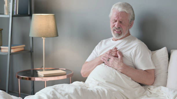 istock Senior Old Man having Chest Pain Sitting in Bed 1345995638