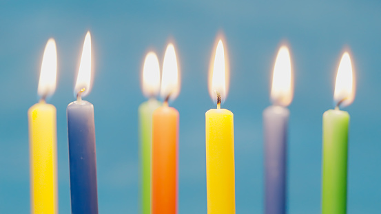 Close up of blow off colorful birthday candels isolated on blue background