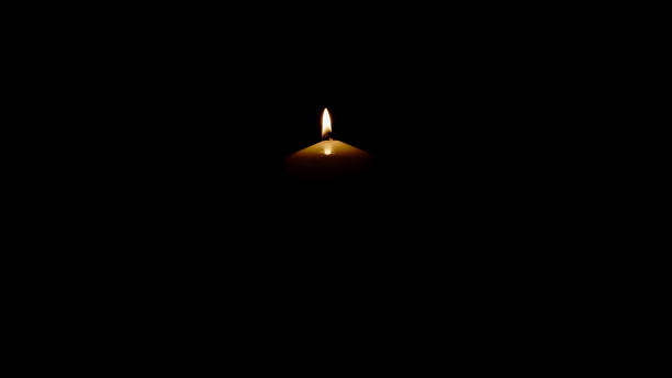 istock Burning candle isolated on black background 1345995939